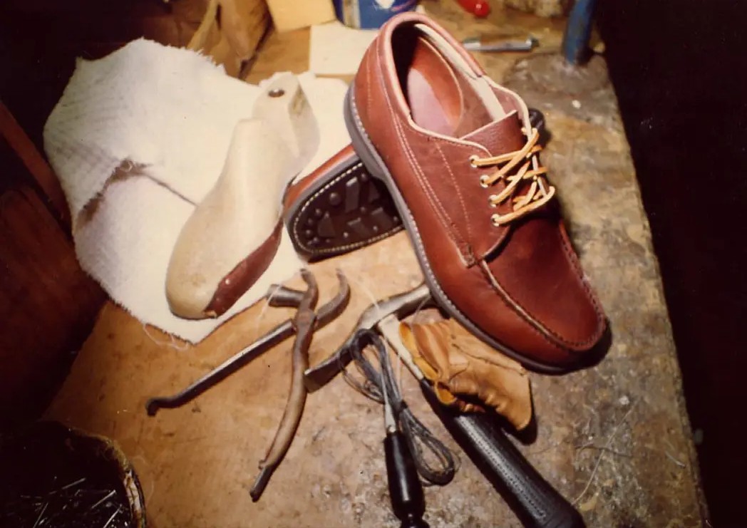 Shoe repair tools and a resoled leather shoe on a workbench